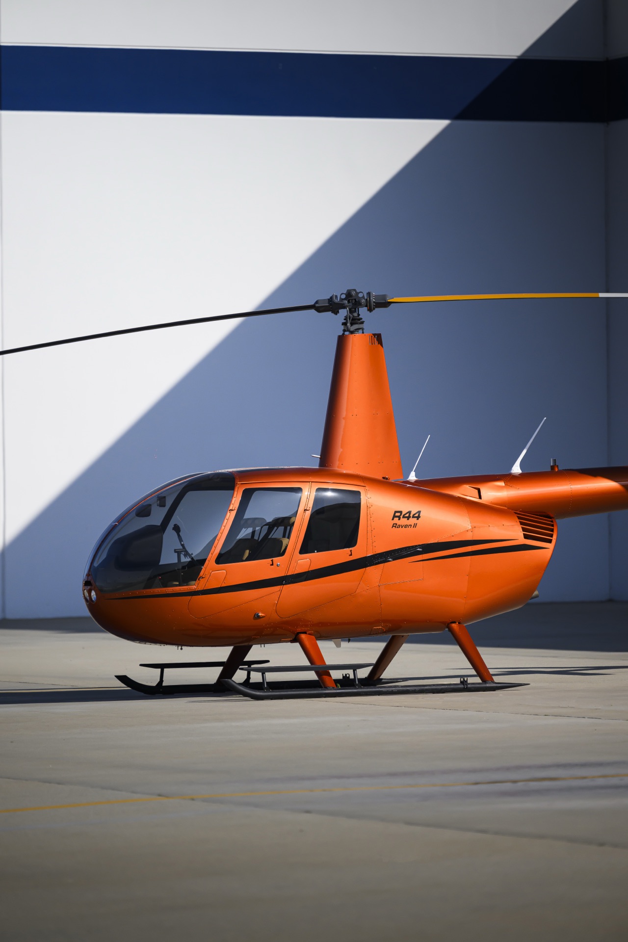 Orange Robinson R44 Raven II on the ramp — current inventory